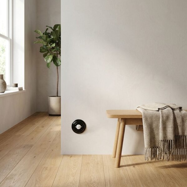 Lightstock Retro Bewegungsmelder aus schwarzem Porzellan, 120°, an heller Wand im Flur neben Holzbank