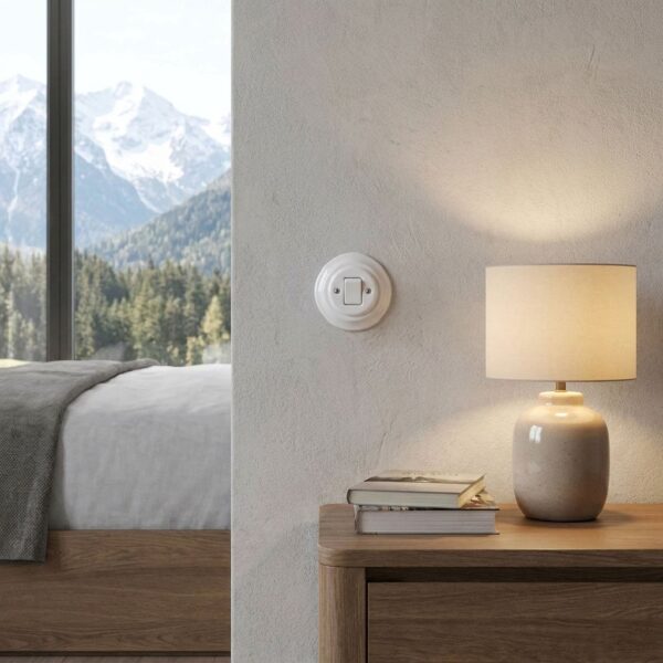 Lightstock Retro Lichtschalter aus weißem Porzellan im Schlafzimmer mit Alpenpanorama und Tischlampe